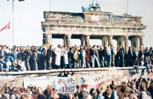 East and West Germans unite on the Berlin Wall at the Brandenburg Gate in 1989