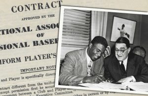 Jackie Robinson signing his historic baseball contract with the brooklyn dodgers