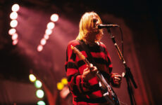 Kurt Cobain on stage playing a guitar.