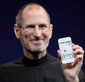A portrait of Steve Jobs holding an Apple iPhone 4 in 2010.