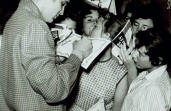Elvis Presley signs autographs for fans early in his career.