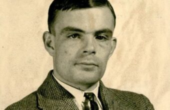 A portrait photograph of Alan Turing in shirt, tie, and suit jacket, taken in 1936 at Princeton University, USA.