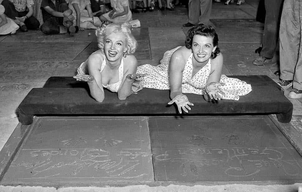 Marilyn Monroe and Jane Russell leave hand and footprints in the Hollywood Walk of Fame.