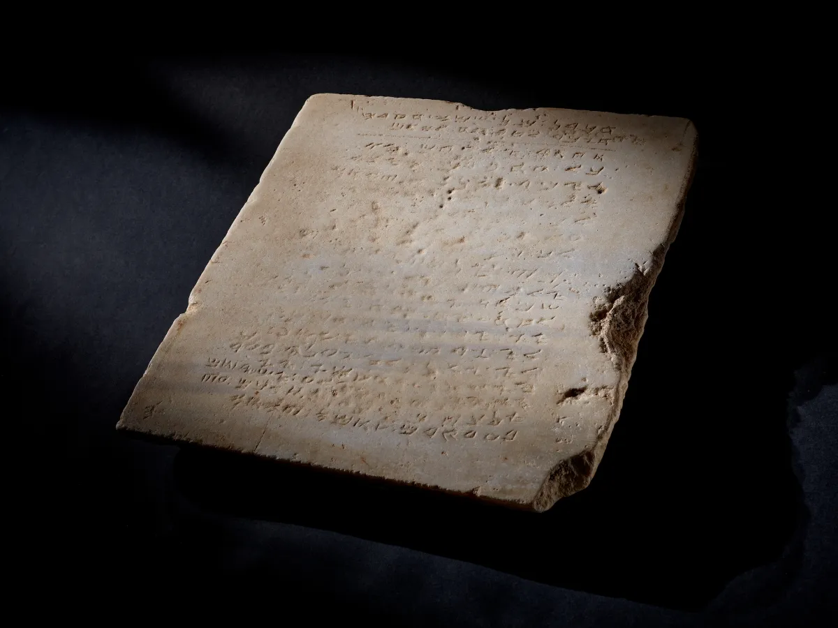 A stone tablet with inscribed ancient Hebrew text of nine of the 10 commandments.