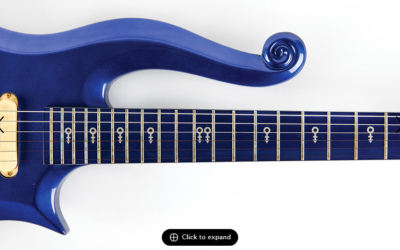 Blue Prince Cloud guitar from 1985's Purple Rain Movie. Image shows a section of the guitar body with a curled upper horn and a neck with symbols.