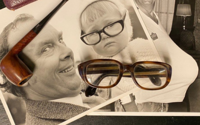 A pair of Eric Morecambe's trademark glasses with photographs and pipe.