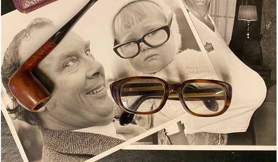 A pair of Eric Morecambe's trademark glasses with photographs and pipe.