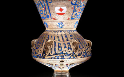 A glass, enamel and gilted mosque lamp sold for over £5 million is seen glowing against a black backdrop.