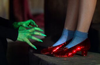 Judy Garland as Dorothy Gale wears Ruby Slippers in the Wizard of Oz. Here, the green hands of the Wicked Witch of the West can be seen grasping for them.