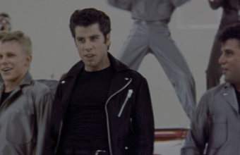 John Travolta as Danny Zuko singing Greased Lightinin with the T Birds in Grease