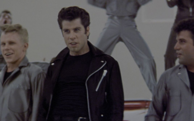 John Travolta as Danny Zuko singing Greased Lightinin with the T Birds in Grease