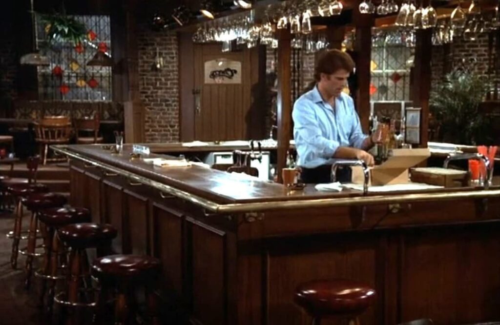 Set of TV sitcom Cheers showing bar, door, and actor Ted Danson as Sam Malone.