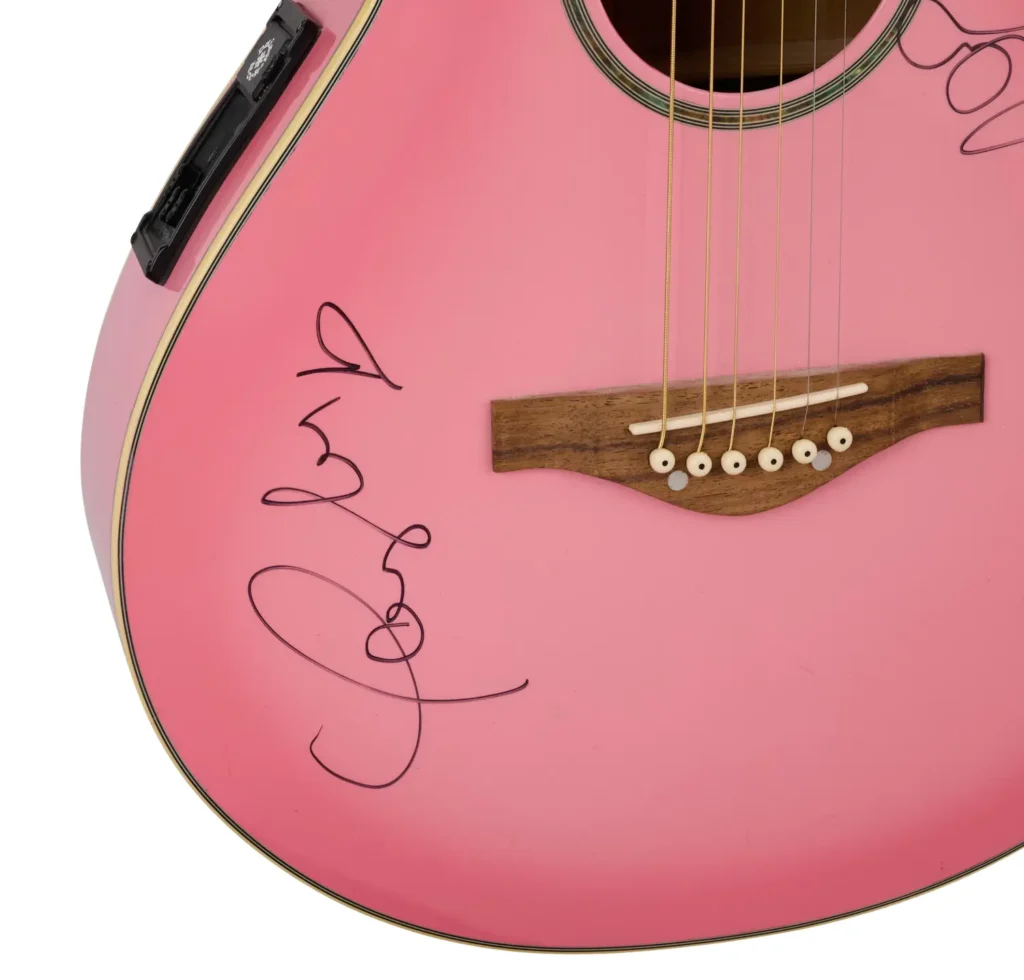 Pink guitar signed by Taylor Swift and Miley Cyrus.