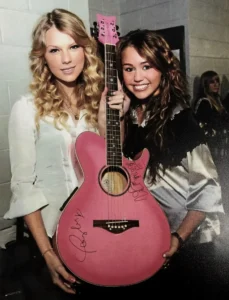 Taylor Swift and Miley Cyrus with a pink accoustic guitar they have both signed at the Staples Center in Los Angeles before the 2009 Grammy Awards.