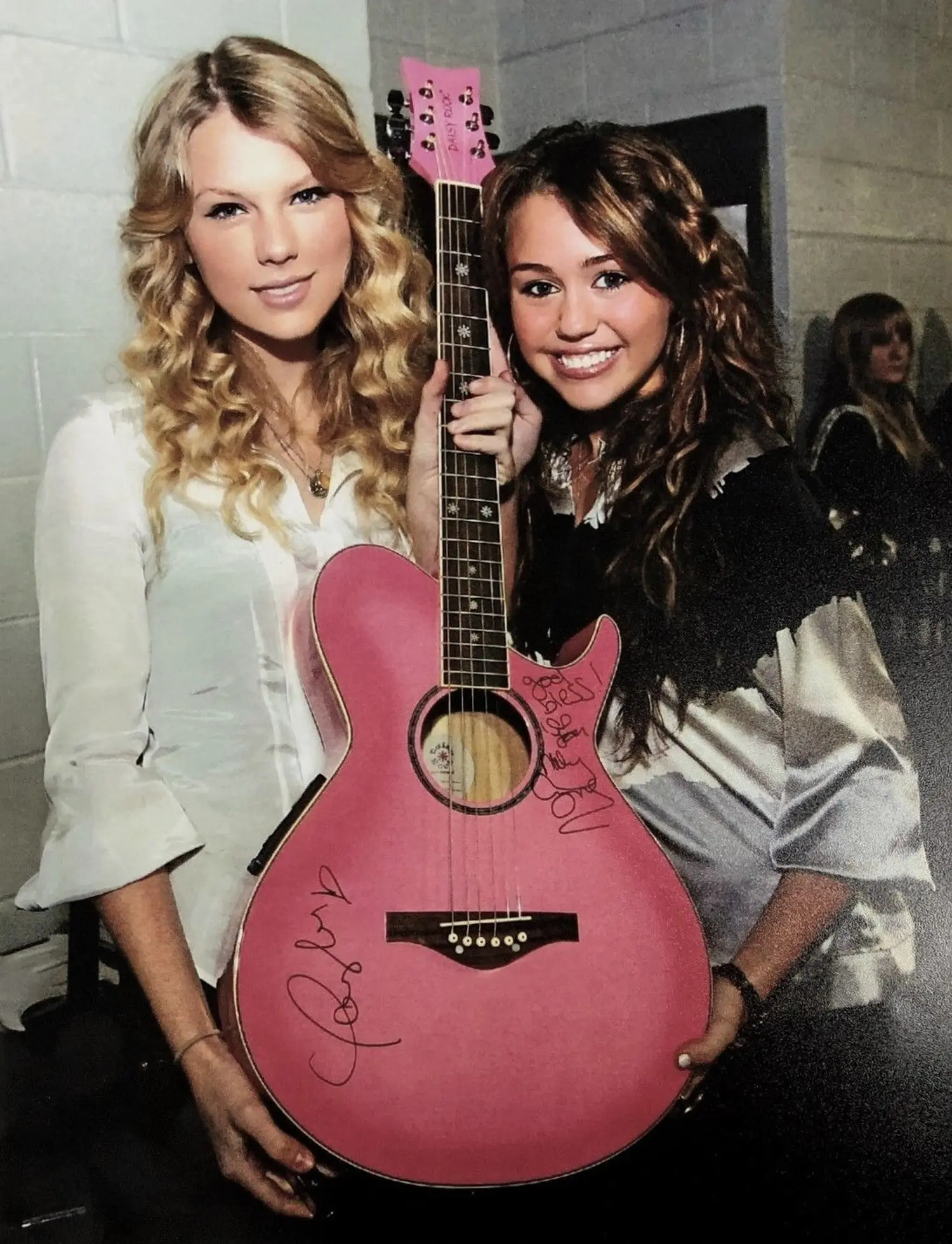 Taylor Swift and Miley Cyrus with a pink accoustic guitar they have both signed at the Staples Center in Los Angeles before the 2009 Grammy Awards.