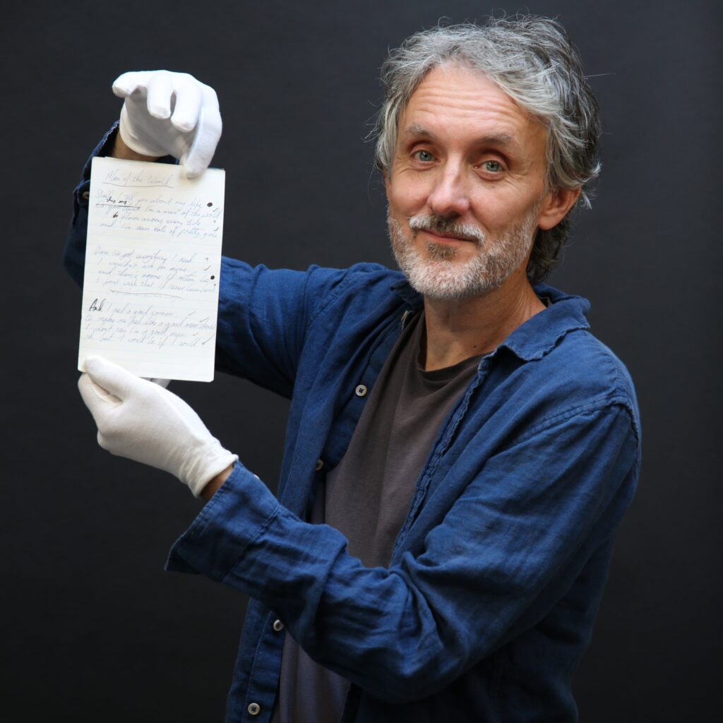 John Silke of Ewbank's auctioneers holding lyric sheet from Fleetwood Mac's Man of the World. 