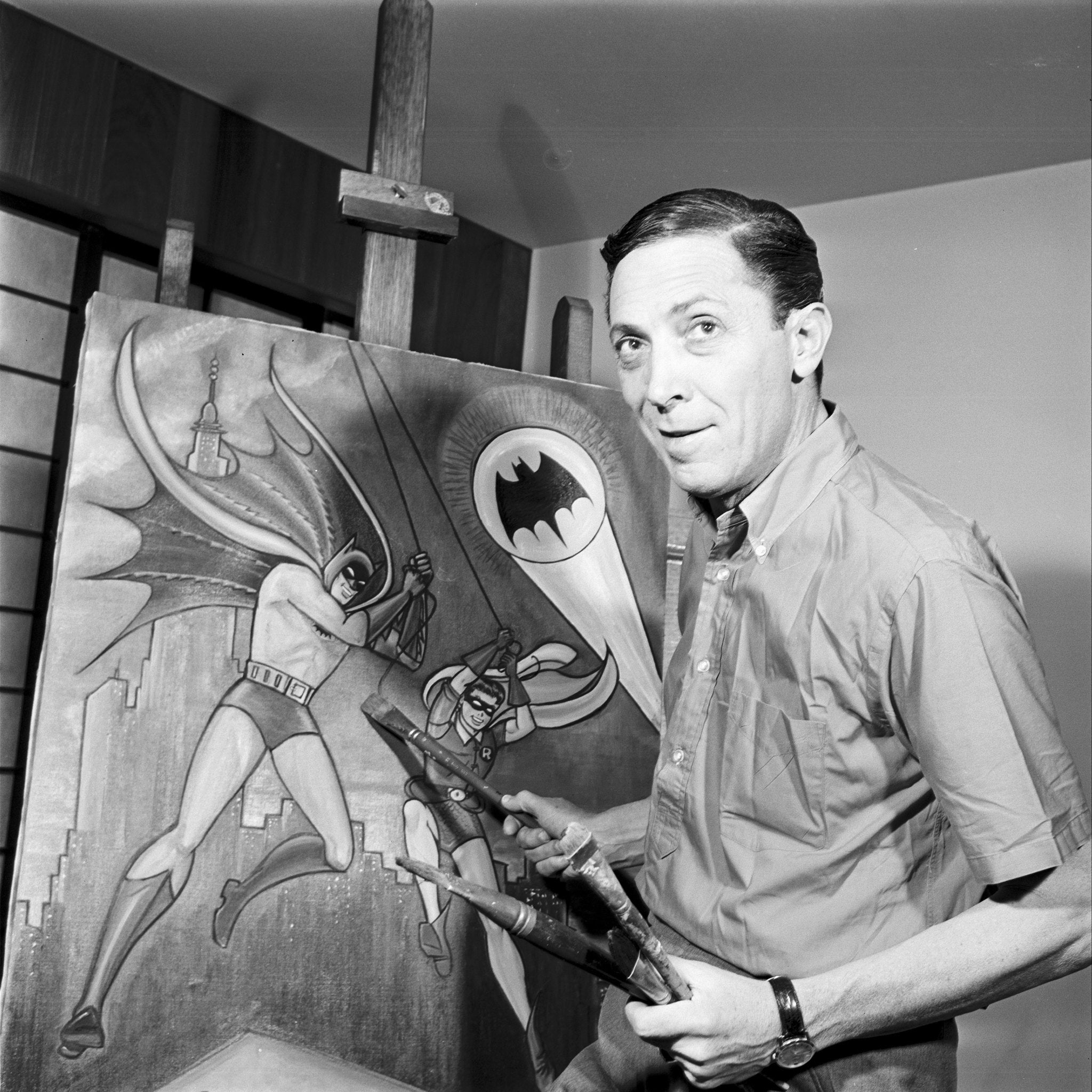Bob Kane in front of a canvas depicting Batman and Robin.