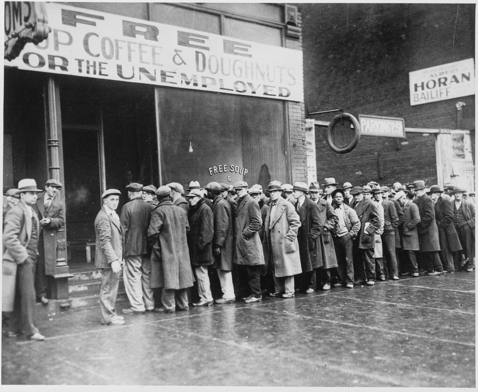Unemployed men queued outside a depression soup kitchen opened in Chicago by Al Capone. February 1931.
