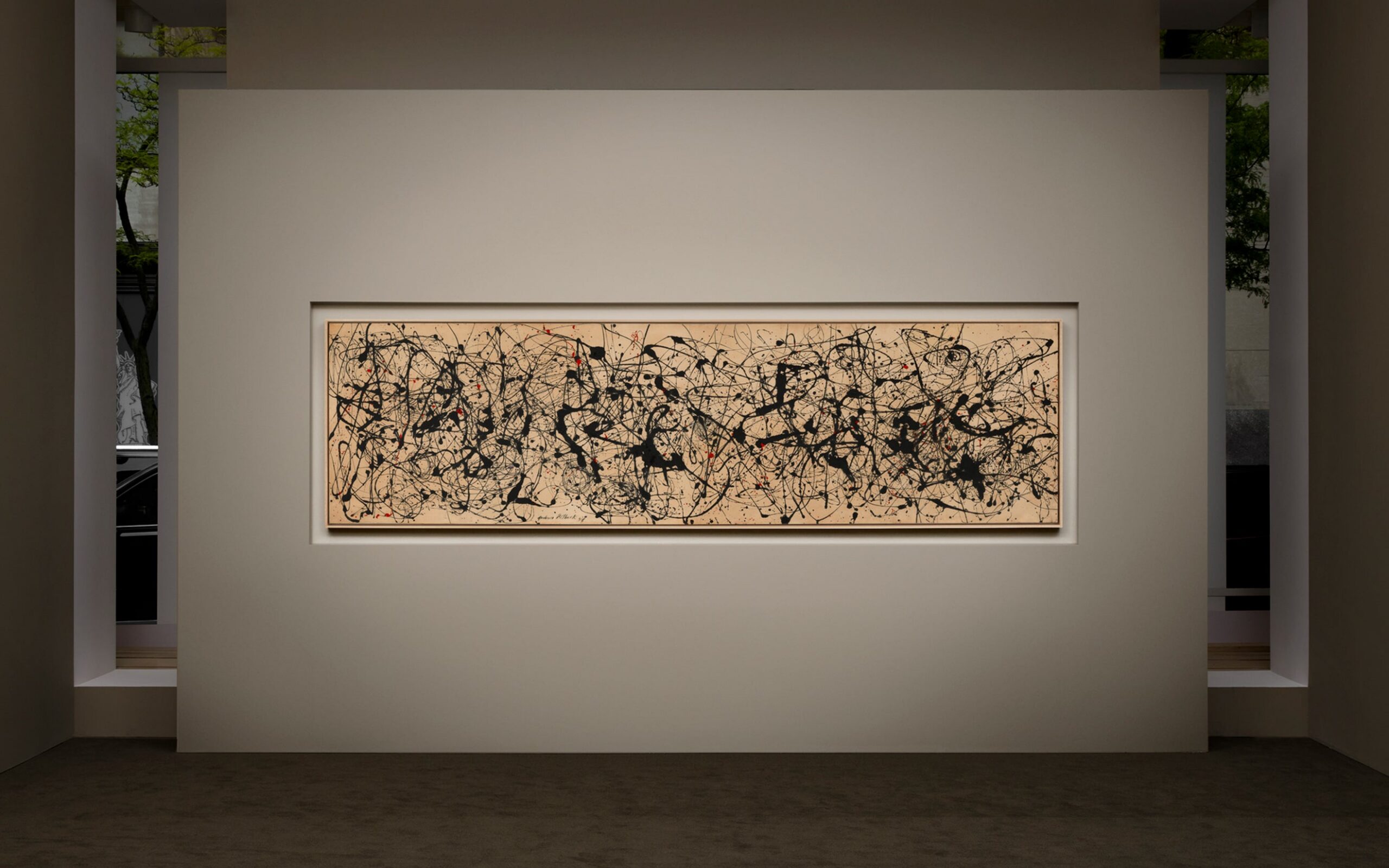 A vast field of black paint flung and dripped across the canvas, with sparing touches of red breaking up the tangle of lines. Spanning more than 11 feet, it is the largest of Pollock's drip paintings still in private hands.